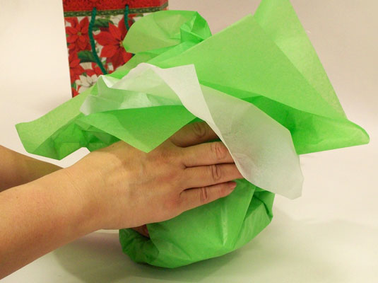 Gather up the tissue paper, loosely, over the gift.